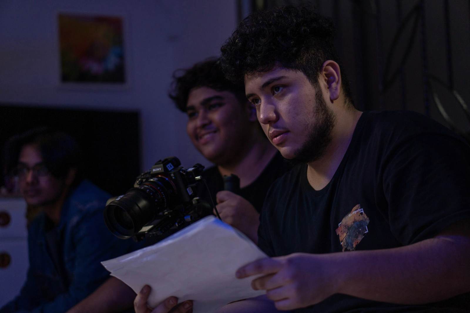 Crew discussing a shot around a gimbal rig and monitor under blue set light
